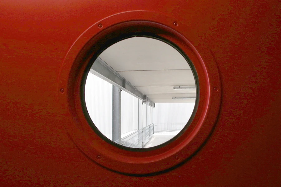 Rundes Fenster durch das man ein Parkhaus von innen sieht